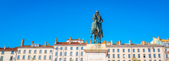 Lyon city skyline and an equestrian statue of King Louis XIV, at the Place Bellecour plaza, the...