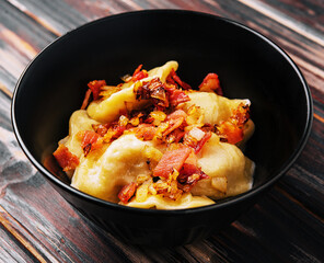 Baked potato dumplings with fried bacon and onions