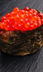 Gunkan ikura with caviar on a black background