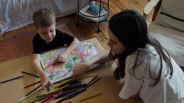 Creativity with son. Mom and son draw together with colored pencils. Games at home.
