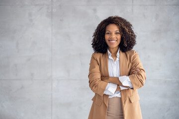 Fototapeta na wymiar Beautiful young african american businesswoman posing on grey background