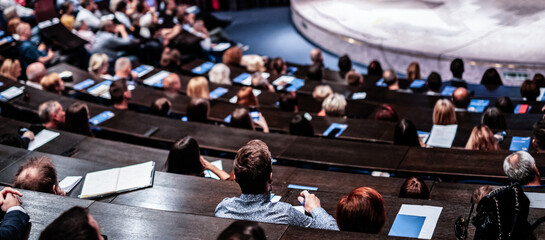 Obraz premium Business and entrepreneurship symposium. Audience in conference hall. Rear view of unrecognized participant in audience