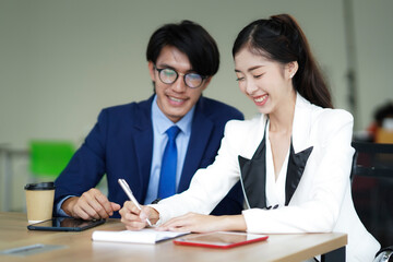 Business man encouraging business woman. Meeting. Work planning at office, working in team meeting with project planning documents on meeting table.