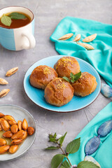Traditional turkish dessert sekerpare with almonds and honey on gray concrete, side view.