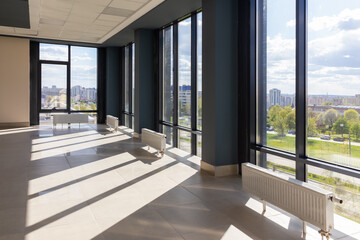 Fototapeta premium Stairs in a concrete office building in neutral tones, covered with ceramic tiles, with shiny metal railings