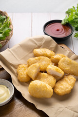 Nuggets on brown paper with ketchup on wooden table.