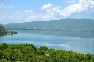 Fototapeta na wymiar beautiful shore of Lake Sevan with clouds and mountain range, Armenia