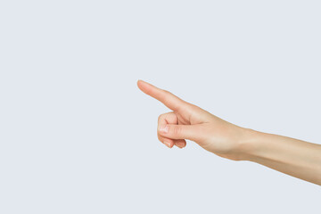 female hand pointing to empty space on blue background