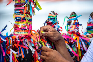Worshipers are tying colored ribbons to the railing of the Senhor do Bonfim church on the first...