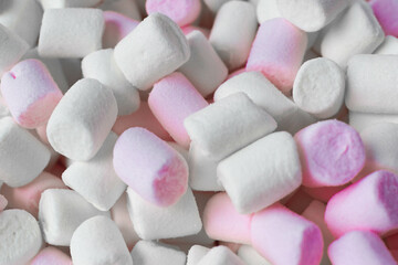 Mini marshmallows in white and light pink. Selective focus. Flat styling.