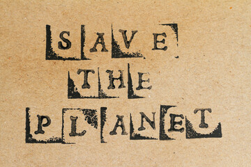 Words save the planet made with letter stamps on recycled brown paper
