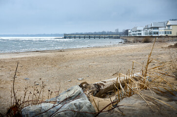 View of Lake Erie in spring. Ice floes on the lake. Pier and houses by the lake. Crystal Beach Waterfront, Ontario, Canada