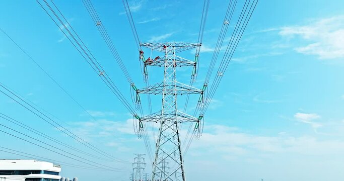 Aerial view of high voltage power tower. Chinese Electric Power maintenance workers work at high altitude.