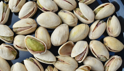 A closeup view of a Single Pistachio seed open in a pile of pistachio