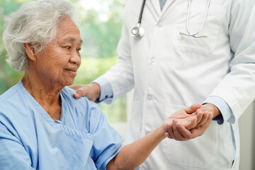 Doctor holding hands Asian elderly woman patient, help and care in hospital.