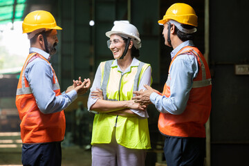 Group of Indian engineers wearing helmet and vest discussing and laughing, candid moment, Industrial factory concept, male and female worker smiling chatting in free time at project. work culture.
