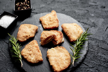 Schnitzel Cordon Bleu fillet cutlet with ham and cheese on a stone background