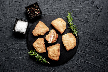 Schnitzel Cordon Bleu fillet cutlet with ham and cheese on a stone background