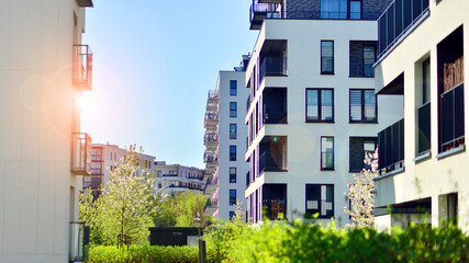 Ecology and green living in city, urban environment concept. Modern apartment building and green trees. Ecological housing architecture. A modern residential building in the vicinity of trees.