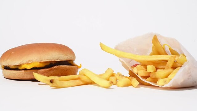 Mcdonalds food, still life of french fries and cheeseburger on white background. Fast food studio shoot video, happy meal 4k