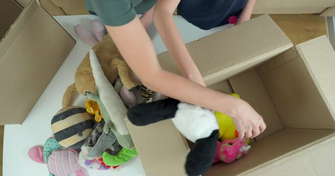 Happy volunteer woman with son separating donations toys in carton package. Generative AI