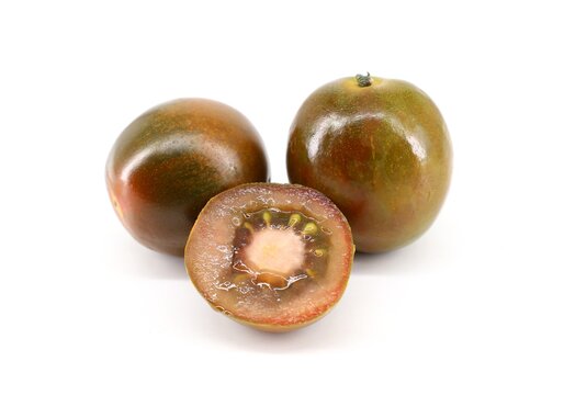 Tomato Camone, an italian variety cultivated in Sicily and Sardinia. The color is dark red  with green shades. White background.
