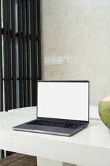 Laptop MacBook Pro computer mockup with white screen on large marble and granite table next to green, ripe coconut in modern, minimal, white Villa in Bali. Bohemian (Boho) and Scandinavian rustic home