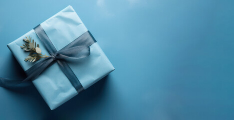 Beautifully Wrapped Present with Blue Paper and Ribbon on Soft Blue Background
