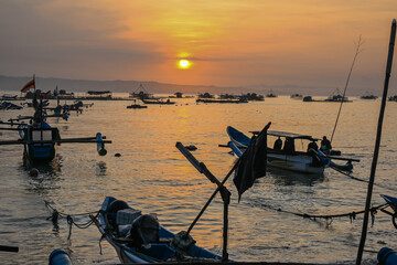 Sunrise on Indonesian Pangandaran beach with white sand and fishing boats