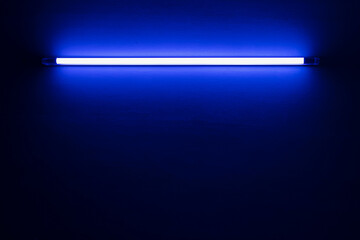blue neon light bulb on white wall..