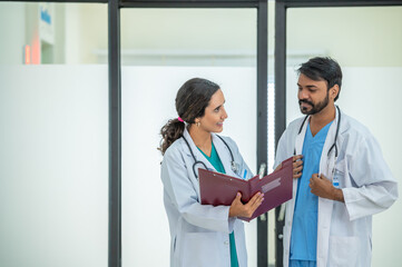 Two doctor hold clipboard document file of patient record talking discussion about treatment...