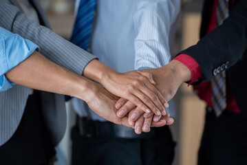 business teamwork putting join hands together. Unity and teamwork show by Stack mix of hands with...
