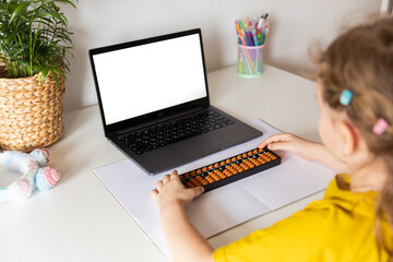 A girl from the back is engaged in mental arithmetic on the abacus online on a laptop, chroma key...