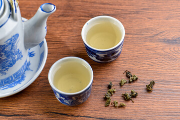 White Ceramic Chinese style Teapot pouring Chinese tea in Ceramic cup. White Ceramic Chinese style Teapot set for tea break time.