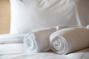 Obraz na płótnie Canvas Soft pillows and white towel on clean white bed. Pillows bed with bedding sheets in bedroom. Bed sheets and pillows messed. Hotel, resort or home can relax on bed for deep sleep.