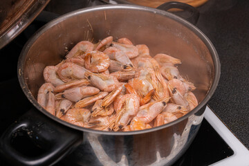 A lot of big shrimps, prawns are being cooked in the cooker 