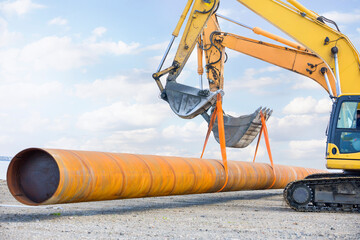 Excavators lift a large pipe together. All movement and functions of a hydraulic excavator are...