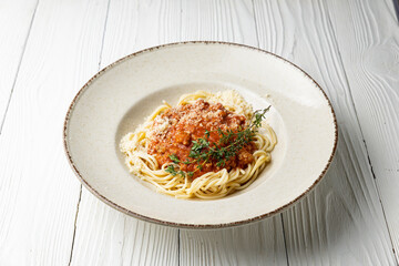 delicious pasta in a plate on a white wooden table. close-up
