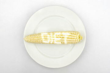 Corn with glowing diet text on a white plate.