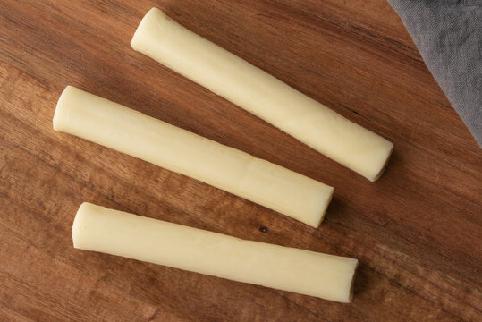 Mozzarella String Cheese on Cutting Board