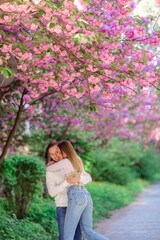 Beautiful young couple, man and woman hugging and having fun in the spring park.