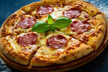 Circle pepperoni pizza with mozzarella cheese on wooden table
