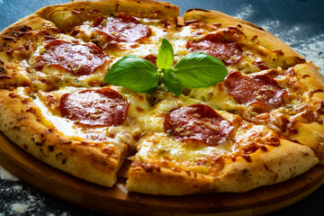 Circle pepperoni pizza with mozzarella cheese on wooden table
