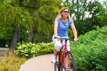 Obraz premium Woman riding bicycle in city park 