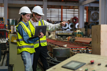 The project manager and engineers are inspecting workpieces and checking standards and safety for products and safety in the factory. Technician and Female Worker Talking on a Meeting in a Factory.