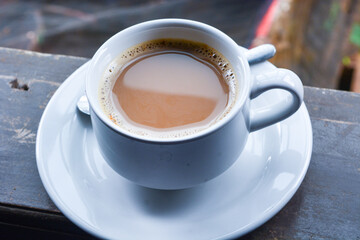 Photo of a cup of coffee milk. White ceramic cup. Flat lay