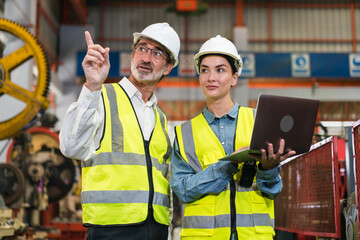 The project manager and engineers are inspecting workpieces and checking standards and safety for products and safety in the factory. Technician and Female Worker Talking on a Meeting in a Factory.