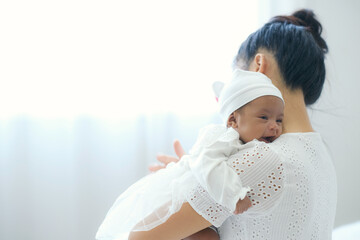 Baby was carrying over her mom shoulder, mother lull baby with love, nursing baby. Bonding between...