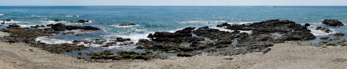 Fototapeta na wymiar Rocks on sea shore in Cala de Mijas, Spain - panorama