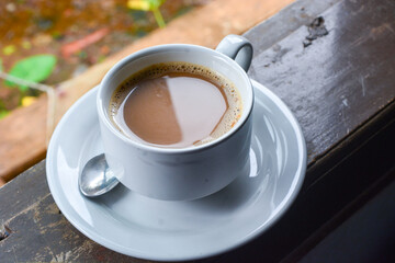 Photo of a cup of coffee milk. White ceramic cup. Flat lay